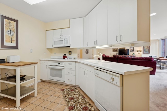 kitchen featuring light tile patterned flooring, sink, white cabinets, and white appliances