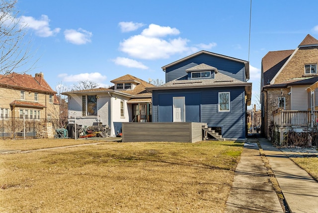 back of property featuring a lawn and fence