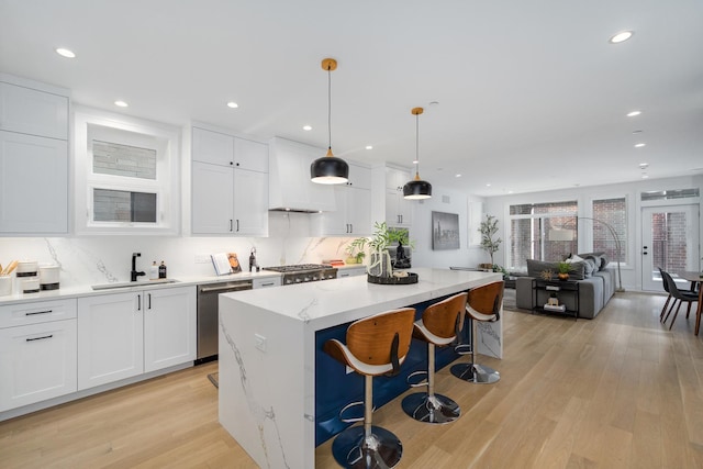 kitchen featuring white cabinetry, hanging light fixtures, and dishwasher