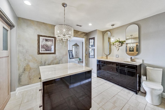 bathroom featuring an inviting chandelier, vanity, tile patterned flooring, and toilet