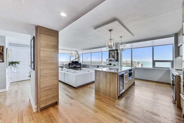 kitchen with a chandelier, a center island, and light wood-type flooring