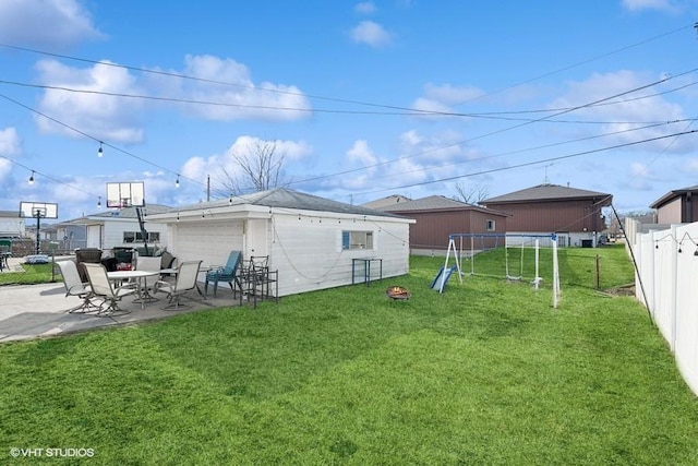 back of house featuring a patio, a trampoline, and a lawn