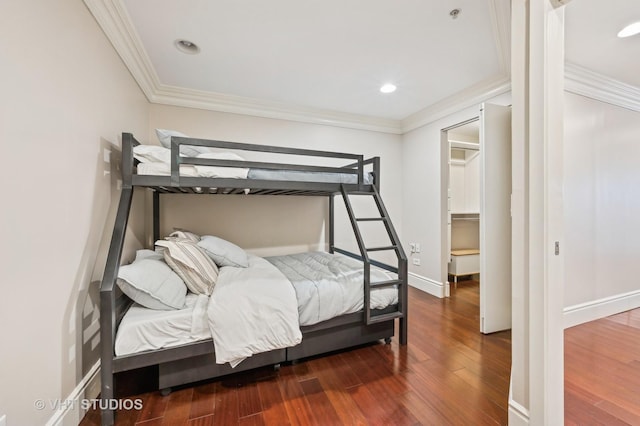 bedroom featuring recessed lighting, baseboards, wood finished floors, and ornamental molding