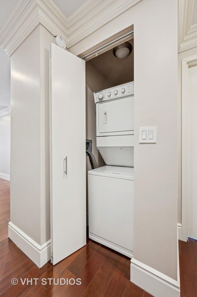 washroom with stacked washer / dryer, baseboards, ornamental molding, laundry area, and dark wood-style flooring