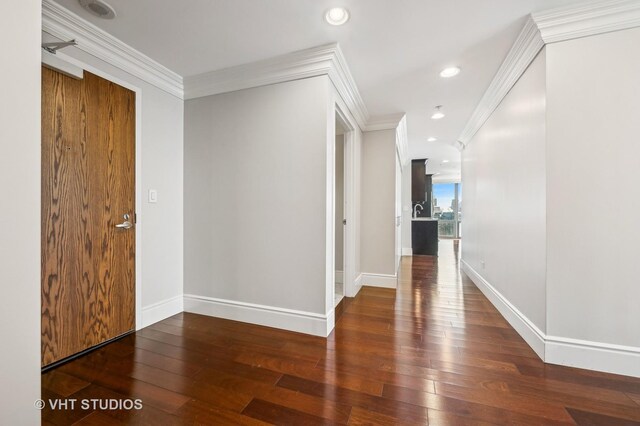 hall featuring crown molding, recessed lighting, and wood-type flooring