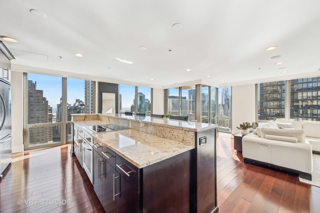 kitchen featuring a wall of windows, dark wood-type flooring, a city view, black electric cooktop, and open floor plan