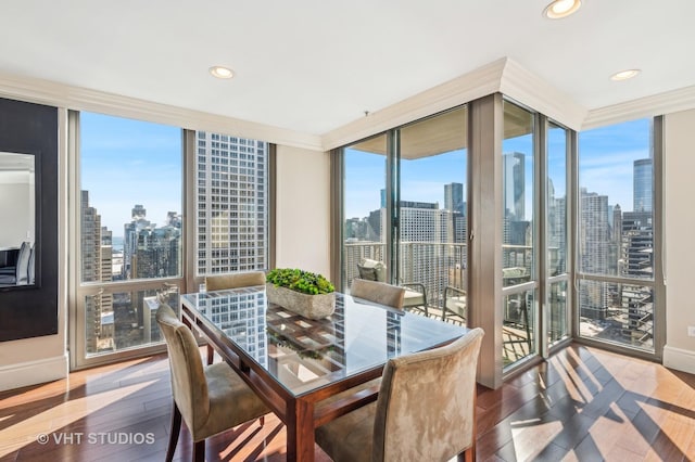 dining space featuring a city view, recessed lighting, wood-type flooring, and expansive windows