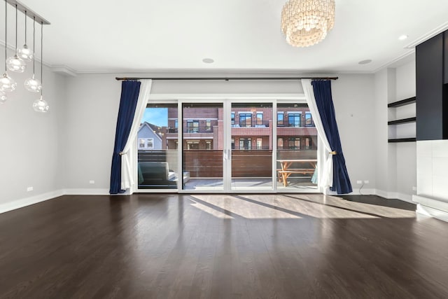 spare room with wood-type flooring, a notable chandelier, and crown molding