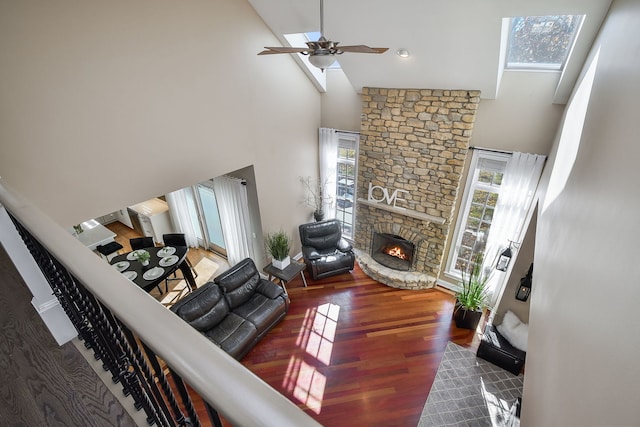 living room with dark hardwood / wood-style flooring, a wealth of natural light, a fireplace, and high vaulted ceiling