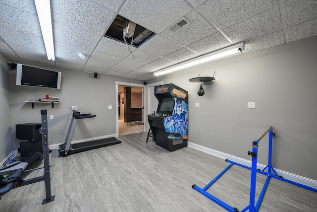 exercise room featuring hardwood / wood-style flooring and a paneled ceiling