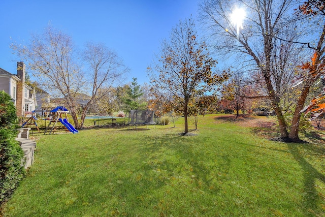 view of yard featuring a playground and a trampoline