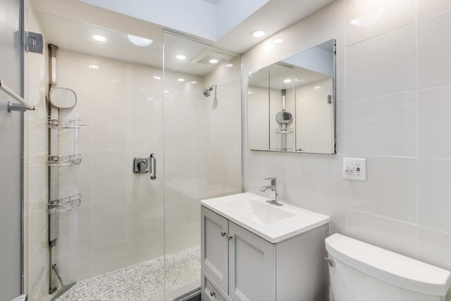 bathroom with vanity, tile walls, an enclosed shower, and toilet