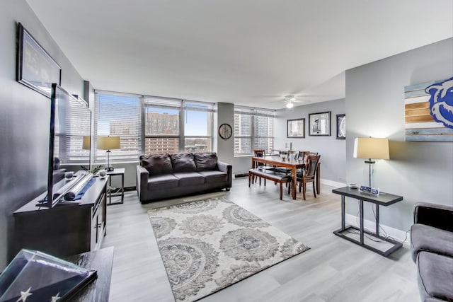 living room featuring ceiling fan and light hardwood / wood-style floors