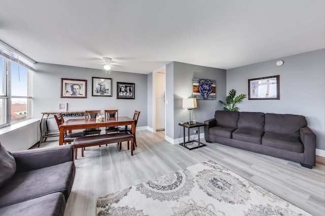 living room featuring ceiling fan and light hardwood / wood-style floors