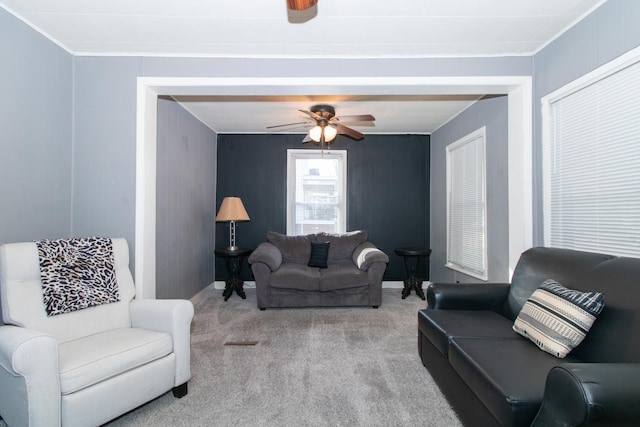 living room featuring ornamental molding, light carpet, and ceiling fan