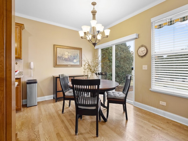 dining area featuring ornamental molding, a chandelier, and light hardwood / wood-style floors