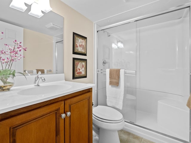 bathroom featuring vanity, tile patterned floors, toilet, and walk in shower