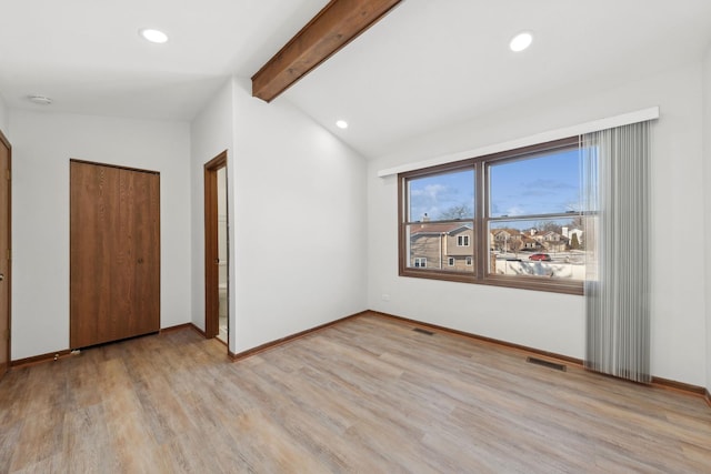 unfurnished bedroom with vaulted ceiling with beams, light hardwood / wood-style floors, and a closet