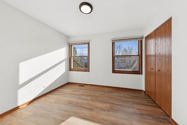 unfurnished bedroom featuring a closet and light hardwood / wood-style flooring