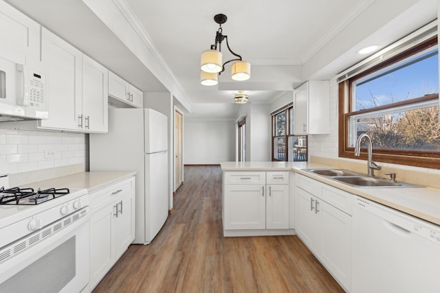 kitchen featuring white cabinetry, white appliances, kitchen peninsula, and sink