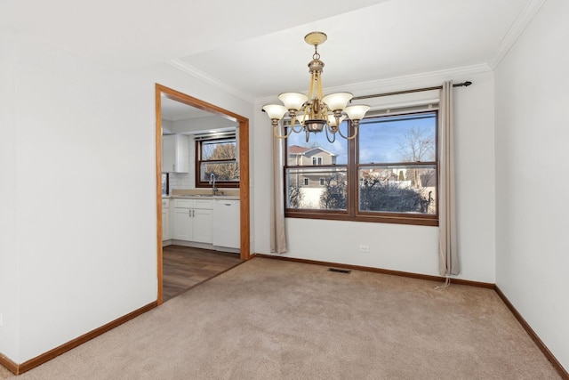 unfurnished dining area featuring ornamental molding, sink, light colored carpet, and a notable chandelier