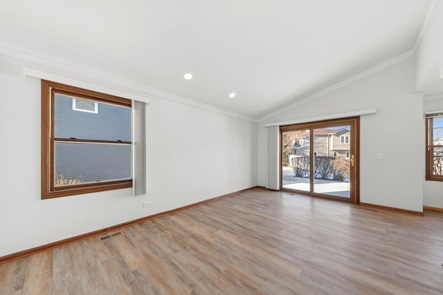 unfurnished room featuring light hardwood / wood-style flooring, crown molding, and vaulted ceiling