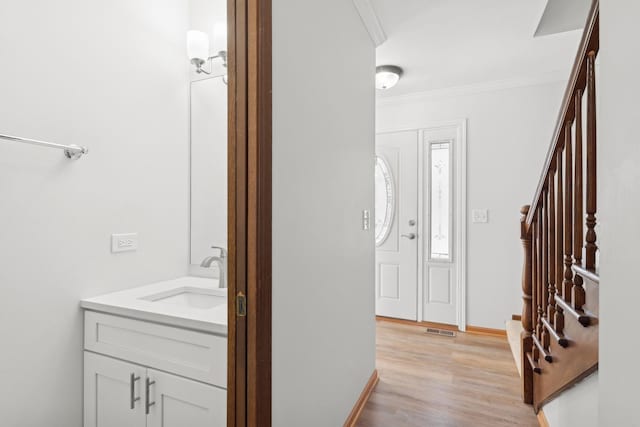 interior space featuring vanity, hardwood / wood-style floors, and crown molding