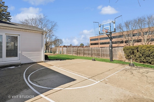 view of sport court featuring basketball hoop and fence