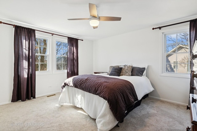 carpeted bedroom featuring baseboards, visible vents, and a ceiling fan