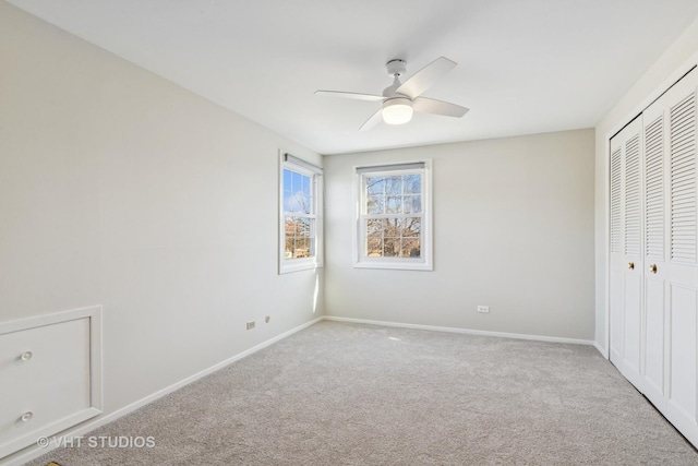 unfurnished bedroom featuring a ceiling fan, carpet, a closet, and baseboards