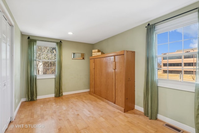 interior space featuring light wood finished floors, visible vents, and baseboards