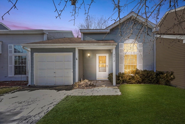 view of front facade with a garage and a lawn