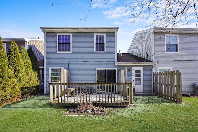 back of property featuring a wooden deck and a yard