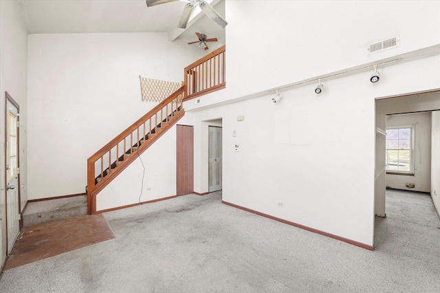 unfurnished living room with light colored carpet, high vaulted ceiling, and ceiling fan