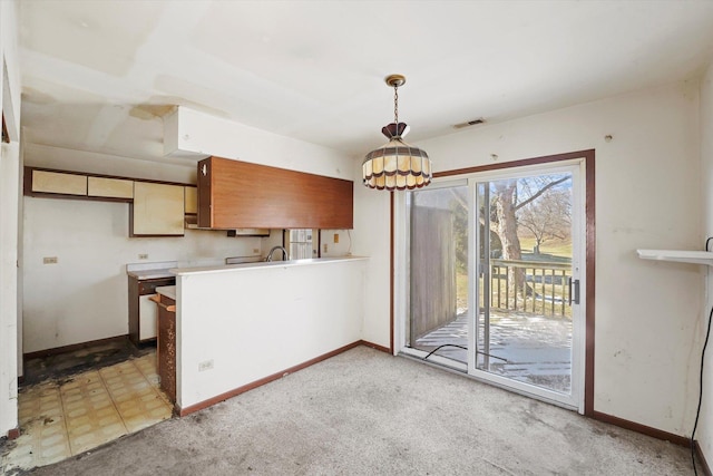 kitchen with pendant lighting, sink, and light colored carpet