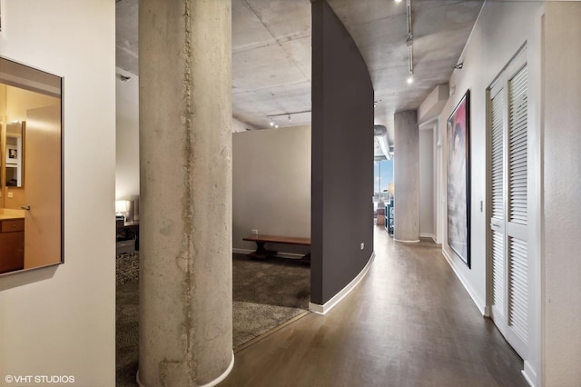 corridor with rail lighting and wood-type flooring