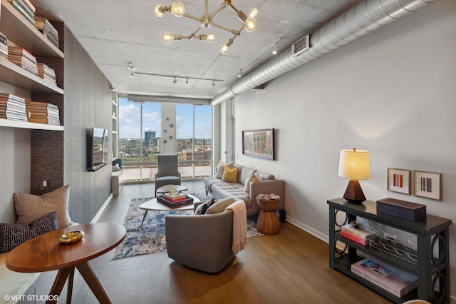 living room with wood-type flooring, floor to ceiling windows, track lighting, and a notable chandelier