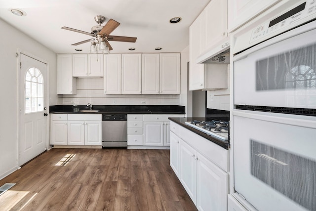 kitchen with dark hardwood / wood-style floors, white cabinetry, sink, decorative backsplash, and white appliances