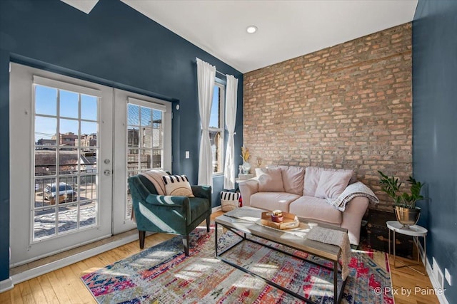 interior space featuring hardwood / wood-style floors, a wealth of natural light, french doors, and brick wall