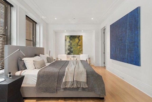 bedroom with crown molding and light wood-type flooring