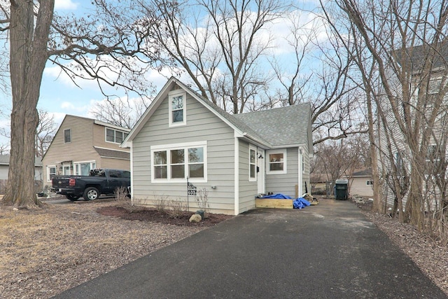 bungalow-style home with a shingled roof