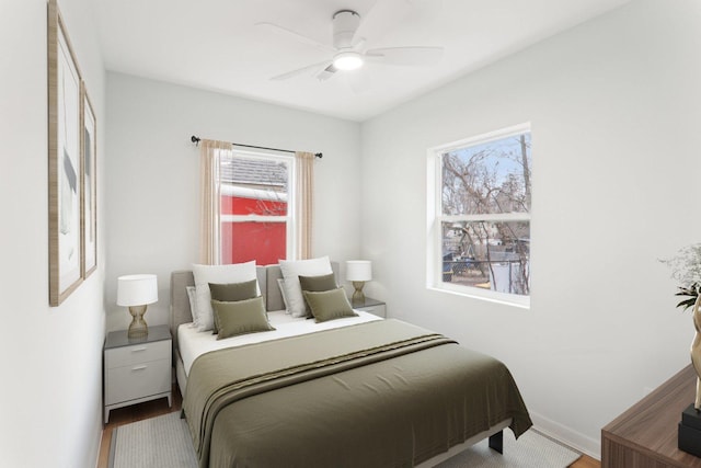 bedroom featuring a ceiling fan, baseboards, and wood finished floors