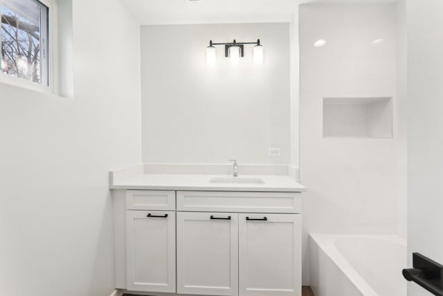 bathroom featuring vanity and a washtub