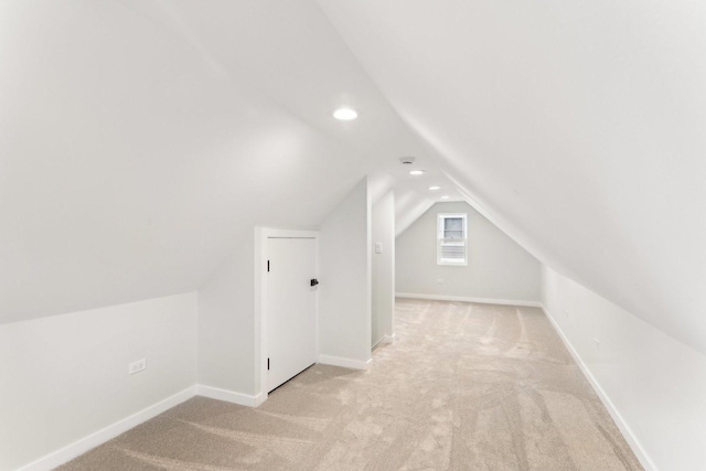 bonus room featuring light carpet, vaulted ceiling, and baseboards