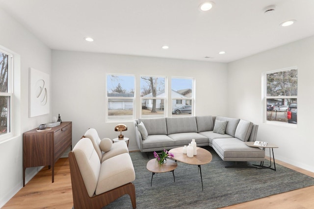 living area featuring light wood-type flooring, baseboards, and recessed lighting