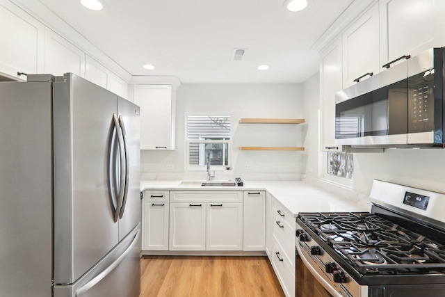 kitchen featuring recessed lighting, light countertops, appliances with stainless steel finishes, white cabinetry, and light wood-type flooring