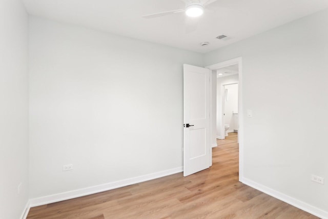 unfurnished room with visible vents, light wood-type flooring, a ceiling fan, and baseboards