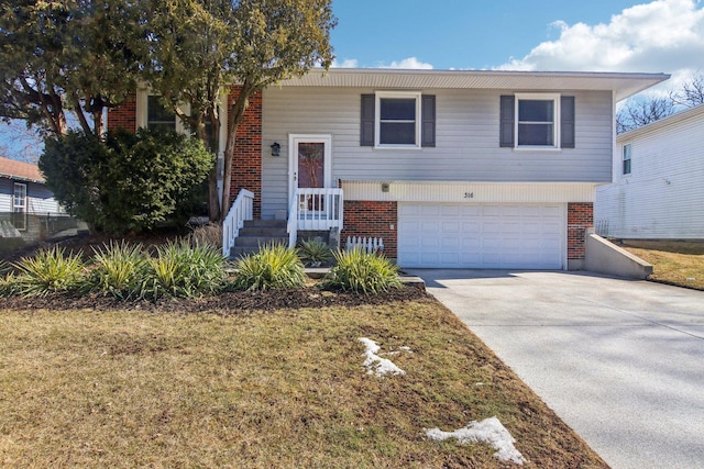 split foyer home with concrete driveway, brick siding, and an attached garage