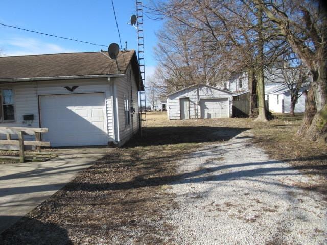 view of home's exterior with a garage and an outbuilding