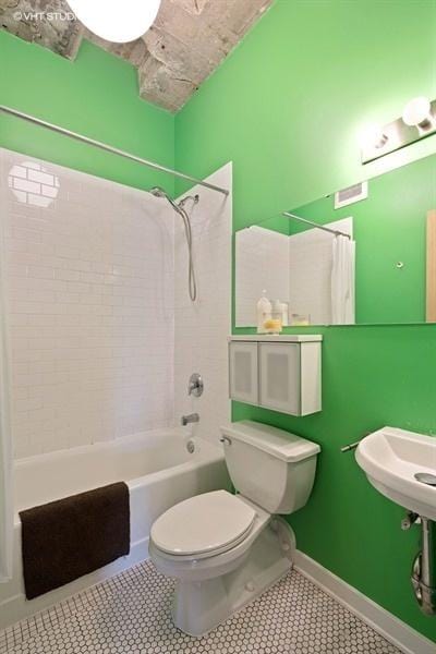 bathroom featuring toilet, tile patterned floors, and shower / bathtub combination with curtain